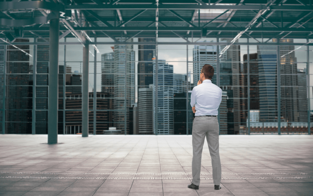 businessman looking out a large window in a building