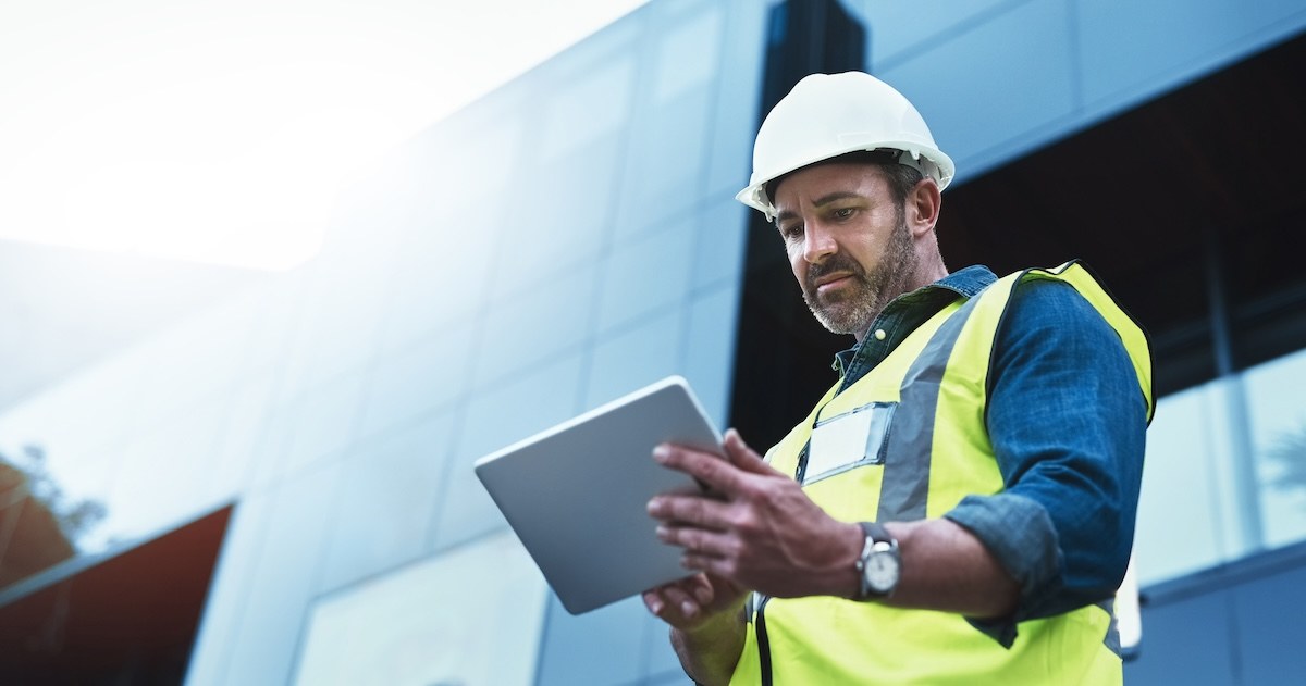 Construction manager reviewing information on a tablet at a construction site