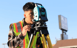 Young construction professional using a surveying instrument in the field