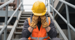 Construction worker feeling stressed out at the job site in need of mental health support
