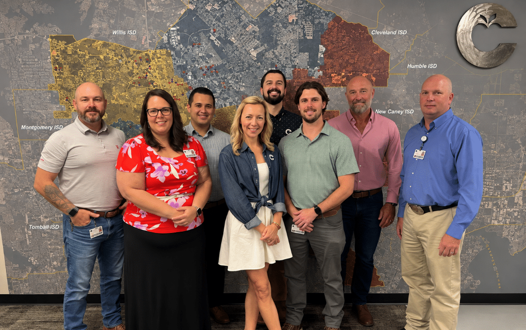 Conroe ISD’s construction professionals gathered in front of a map representing the area they service.
